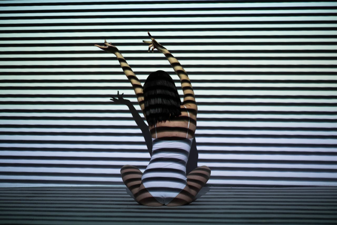 creative-02 Creative double exposure photo of a woman with geometric stripe patterns creating an optical illusion effect.